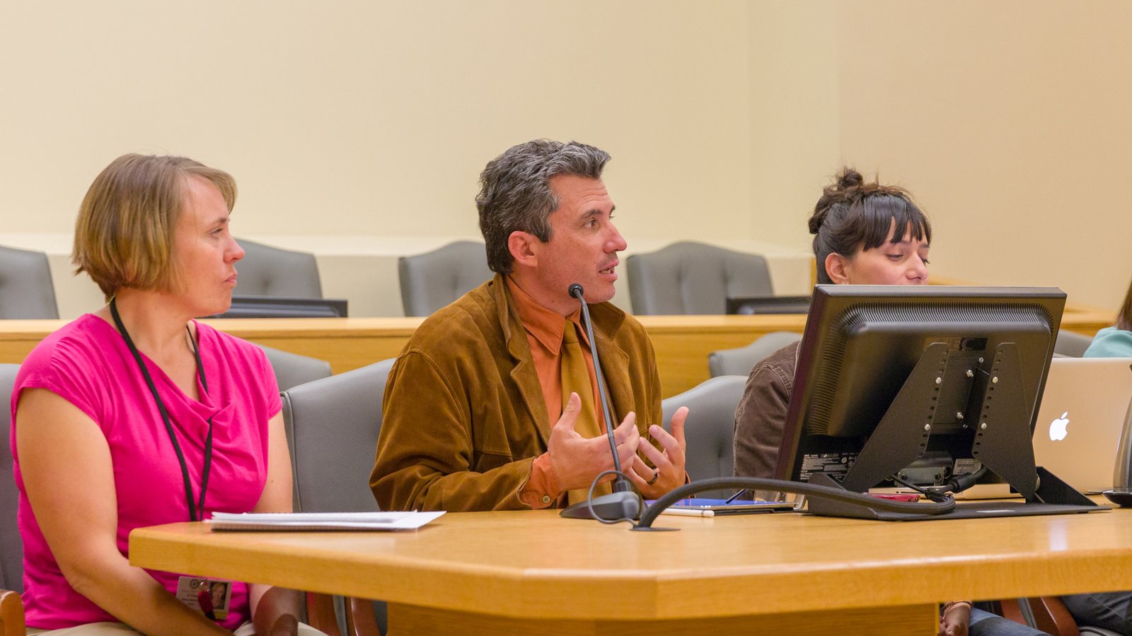 Members of a PSI program team speaking at a convening in a federal courthouse meeting room.